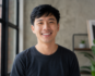 an asian man happily facing the camera